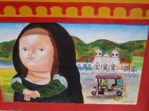 A colorful painting features a plump, Mona Lisa-inspired figure on the left and a lively street scene with a tuk-tuk, colonial church, and green hills on the right, framed by a red and yellow border.