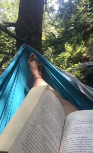Dani's feet and a book in a hammock.