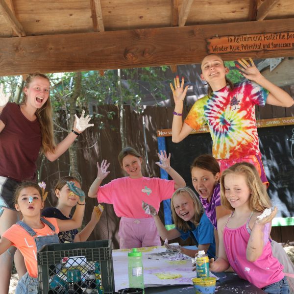 campers and counselors smiling at camera with paint on hands
