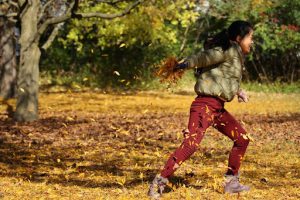 Girl Outside Playing With Leaves