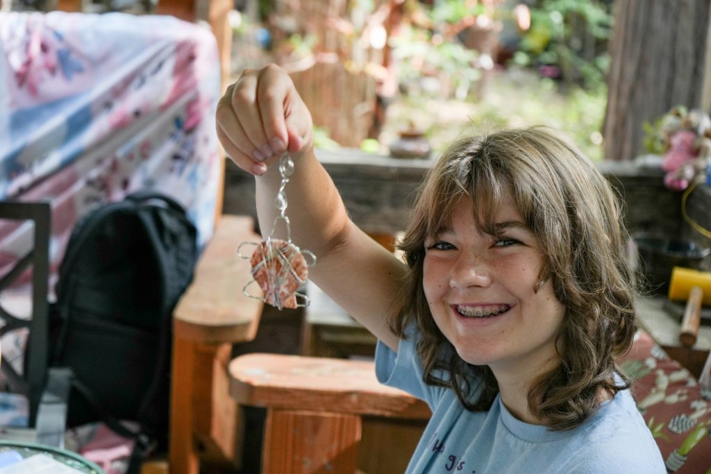 child holding up wire jewelry