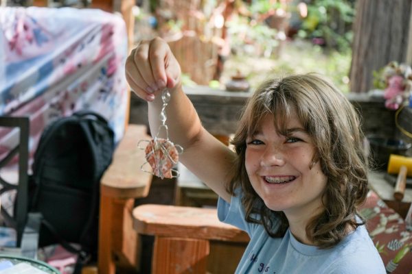 child holding up wire jewelry
