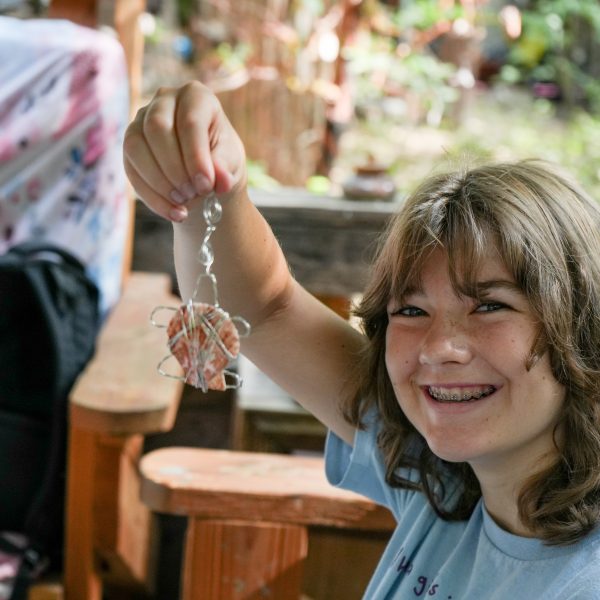 child holding up wire jewelry